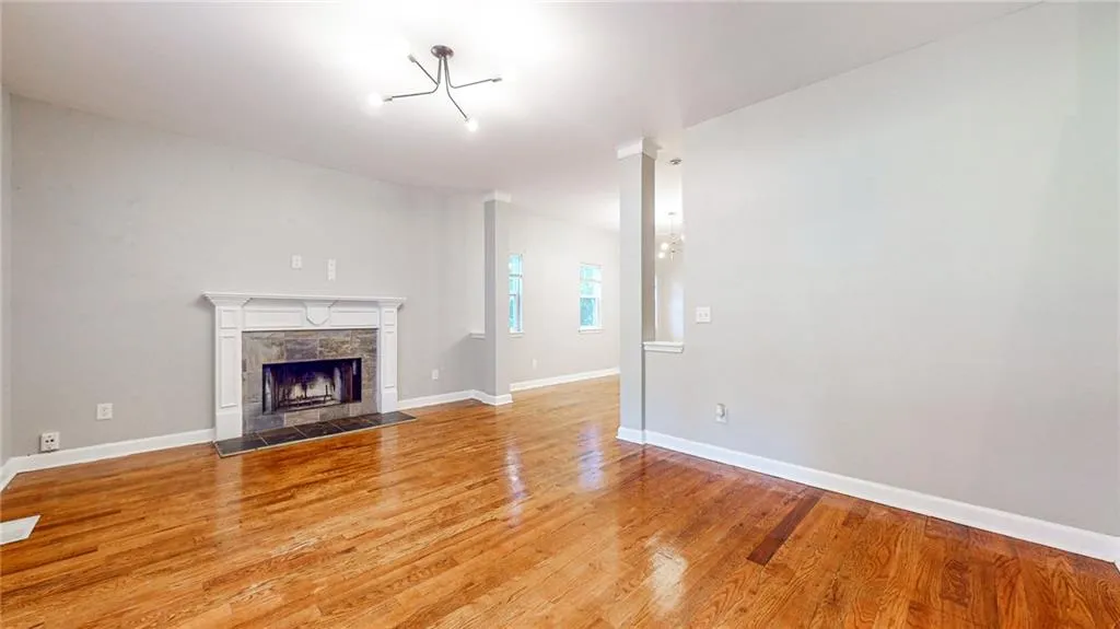 Unfurnished living room with light wood-style floors and a tiled fireplace