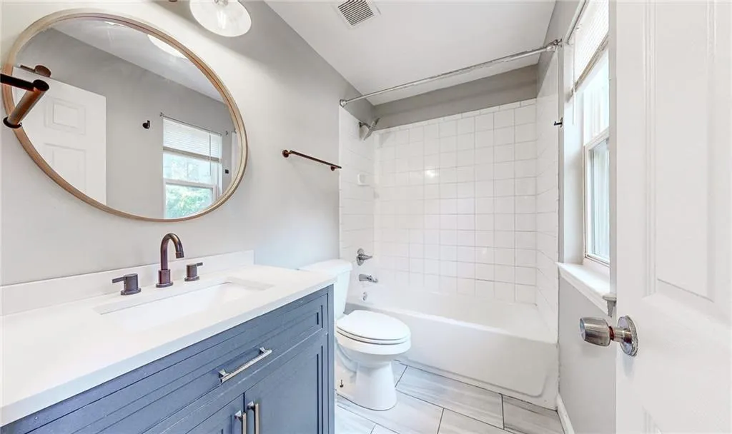 Full bathroom featuring healthy amount of natural light, shower / bathtub combination, and vanity