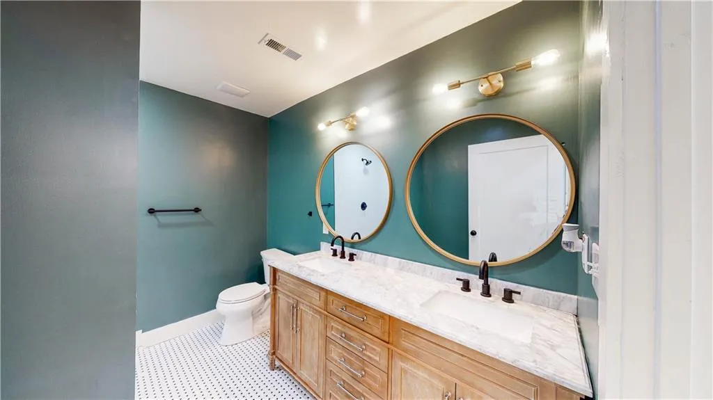 Bathroom featuring double vanity and light tile patterned floors