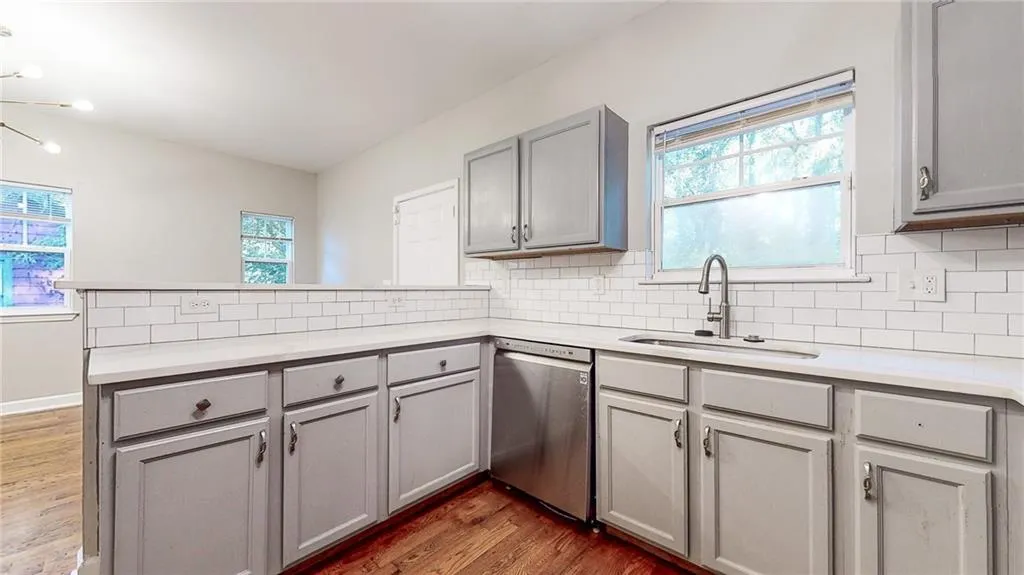 Kitchen featuring a peninsula, gray cabinets, plenty of natural light, and dark wood-type flooring