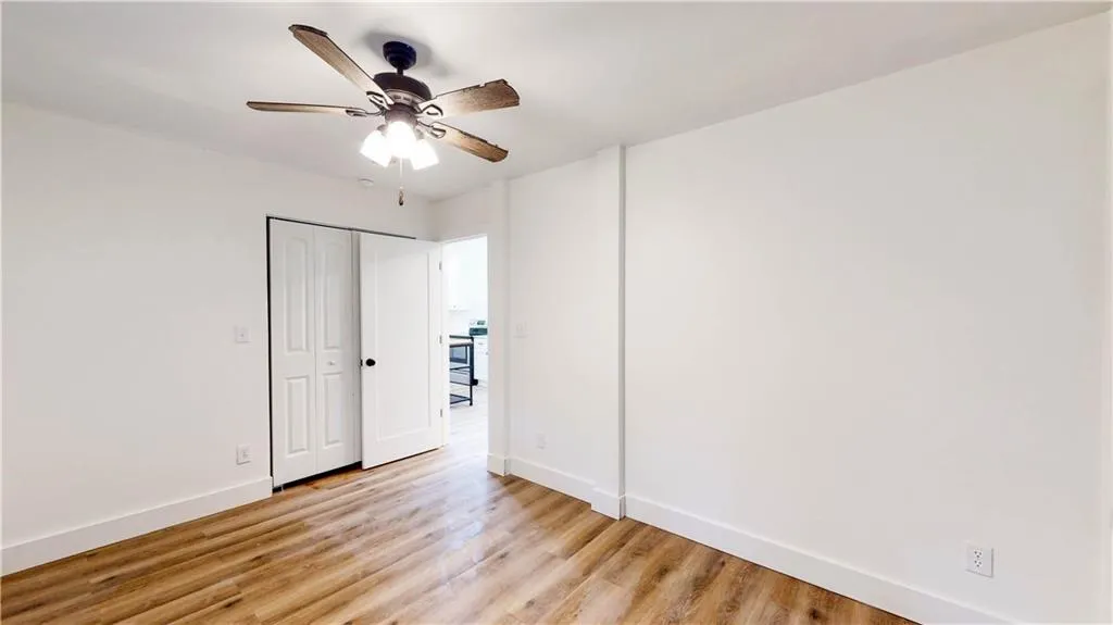 Unfurnished bedroom with light wood-style flooring, a ceiling fan, and a closet
