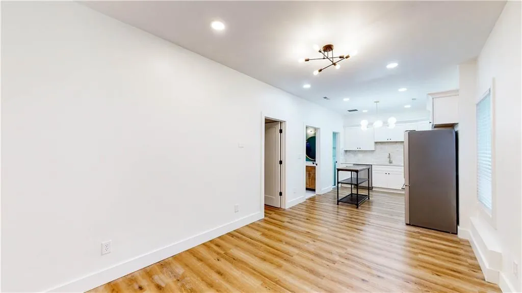 Unfurnished living room featuring a chandelier, light wood finished floors, and recessed lighting