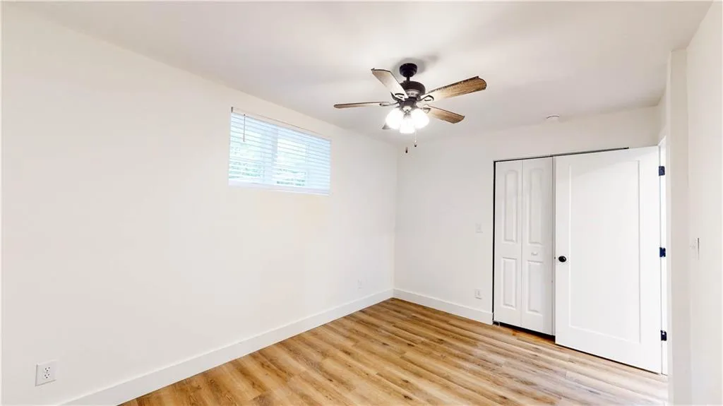 Unfurnished bedroom featuring light wood-style flooring, ceiling fan, and a closet