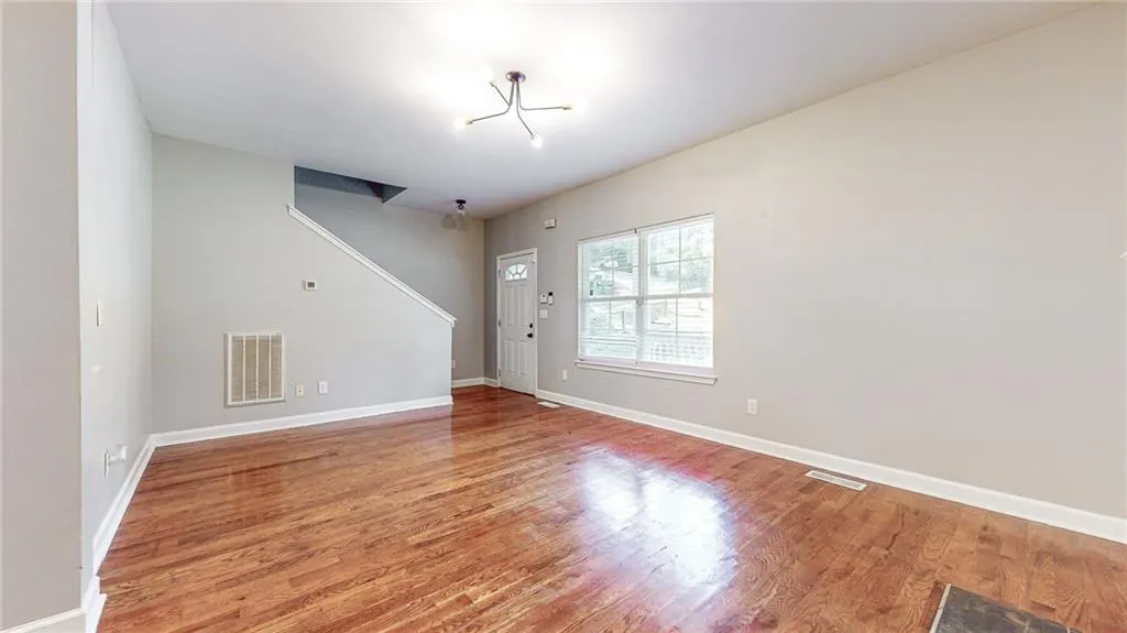 Unfurnished living room with light wood finished floors and a chandelier