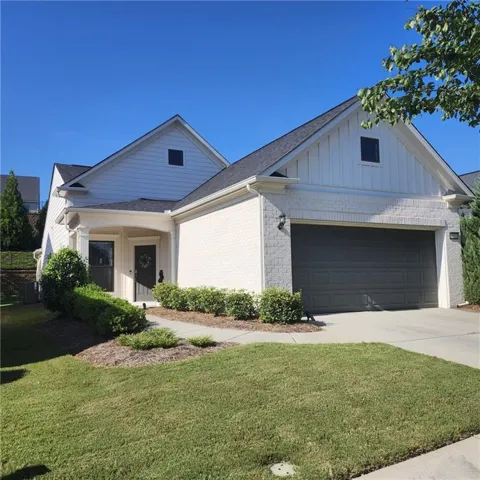 White brick and horizontal siding exterior with a dark gray garage door