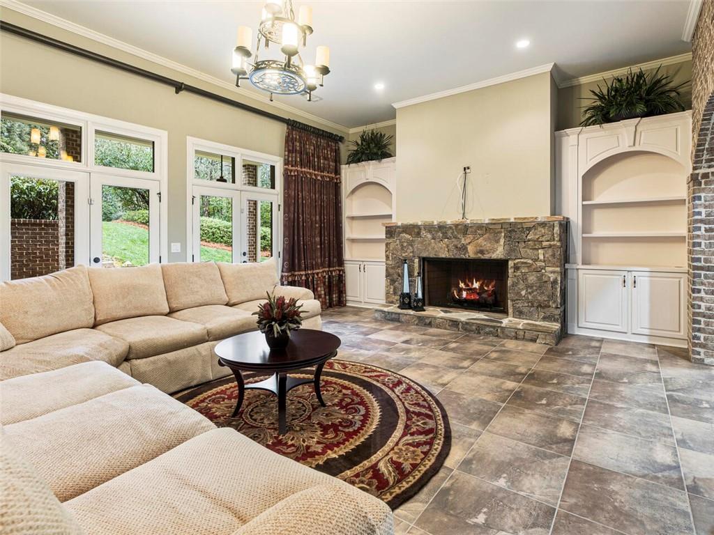 Lower level great room/media room with stone fireplace leads out to patio area