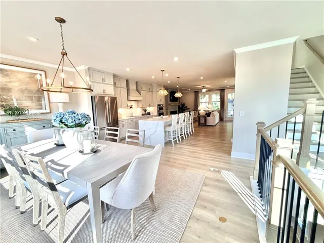 Open-concept main level featuring wood-finish flooring, a contemporary kitchen with stainless steel appliances, and a central island with seating