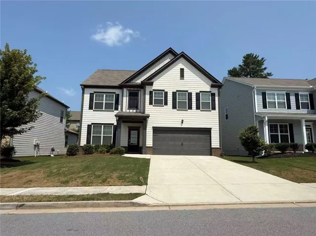Two-story residence featuring white siding and dark trim accents