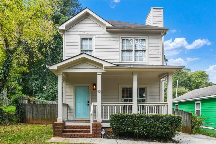 Two-story siding exterior with a covered front porch featuring white columns and railing