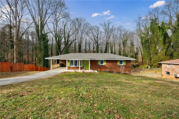 Brick ranch home situated on expansive grounds with mature tree-lined perimeter