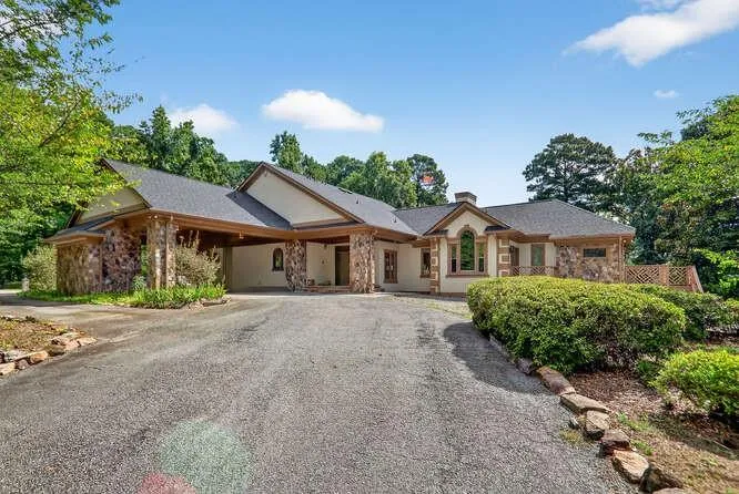 Single story home with stone siding and curved driveway