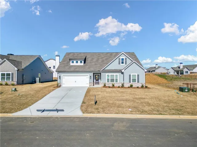 Craftsman inspired home featuring driveway, a residential view, an attached garage, a front yard, and roof with shingles