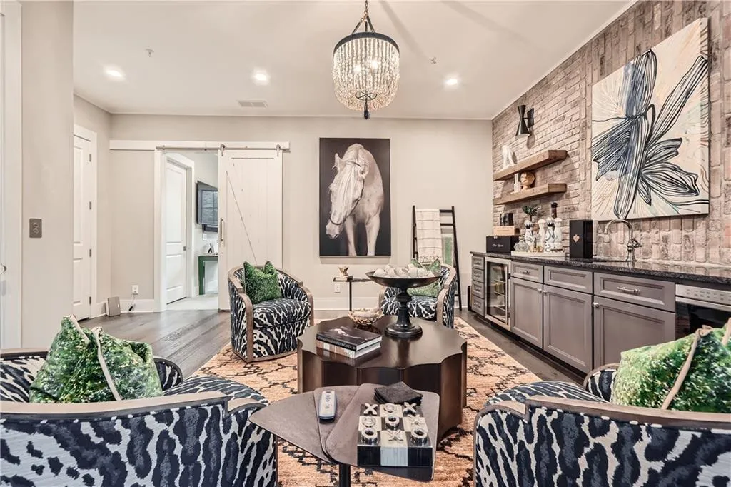 Living room with wine cooler, wood finished floors, bar, a chandelier, and a barn door