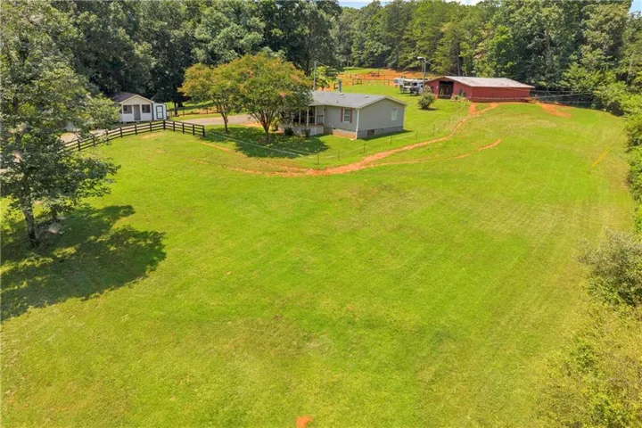 Expansive green lawn surrounding a single-story residence with a covered front porch