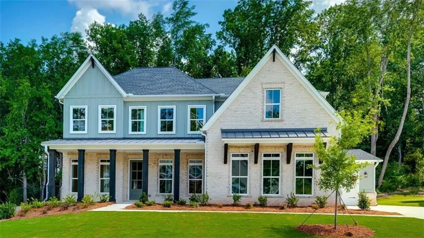Two-story residence featuring light brick and board and batten siding
