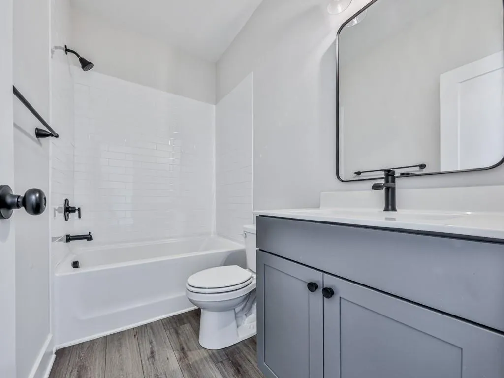 Bathroom with wood-style floors, vanity, and bathing tub / shower combination