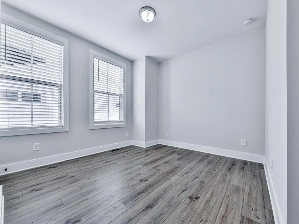 Empty room featuring wood-style finished floors and baseboards