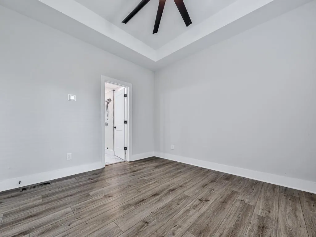 Spare room featuring wood-style  floors and a tray ceiling