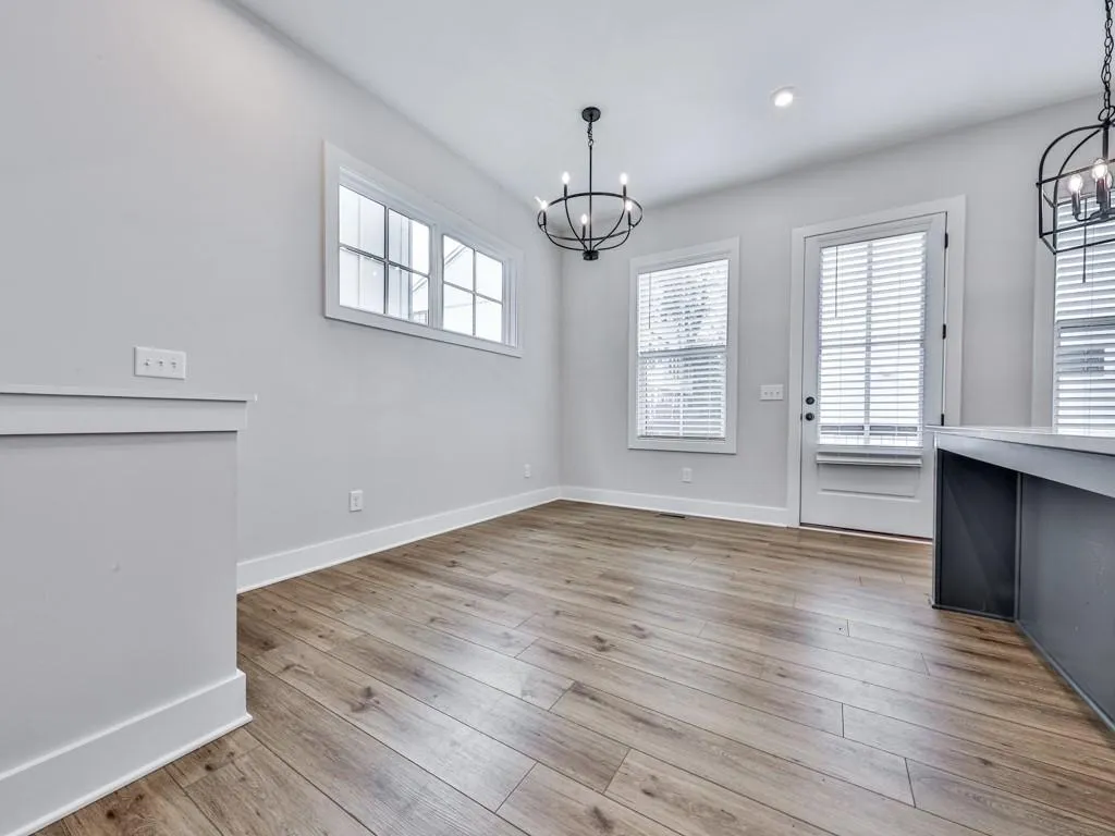 Unfurnished dining area with a chandelier, LVP floors, and recessed lighting