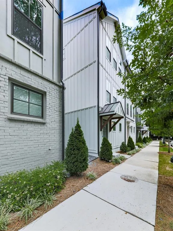 View of property exterior featuring board and batten siding and brick siding