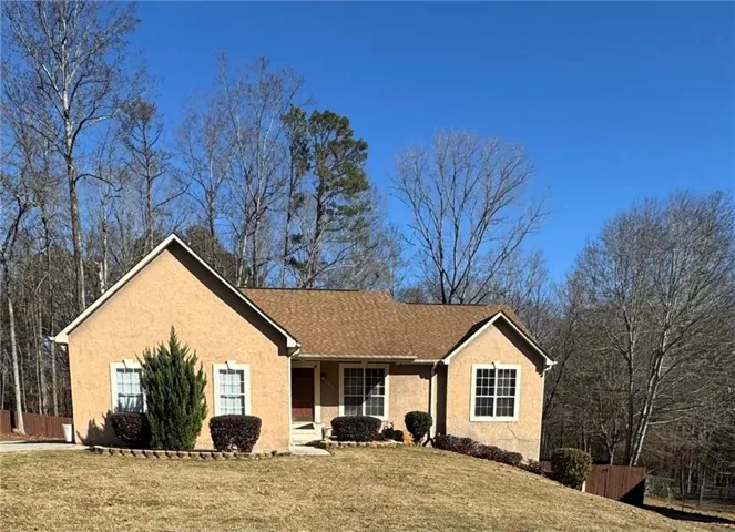 Single story home featuring stucco siding, a porch, and a shingled roof