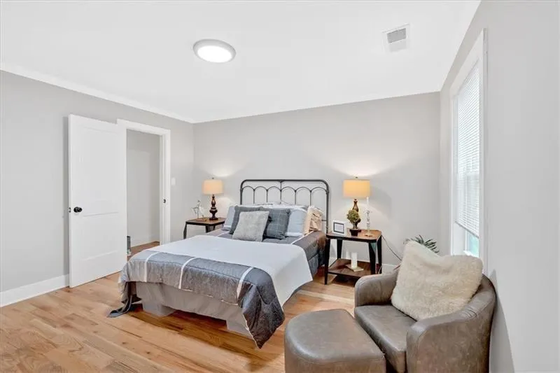 Bedroom featuring light wood finished floors and crown molding