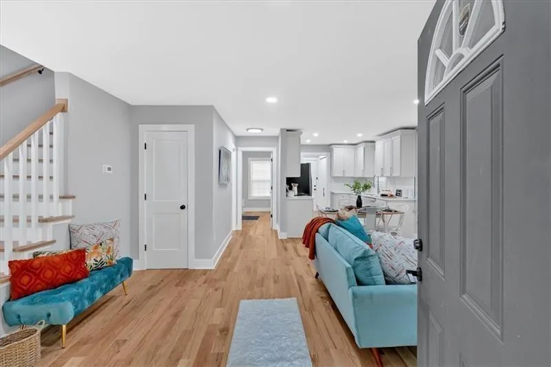 Living room featuring light wood finished floors, stairs, and recessed lighting
