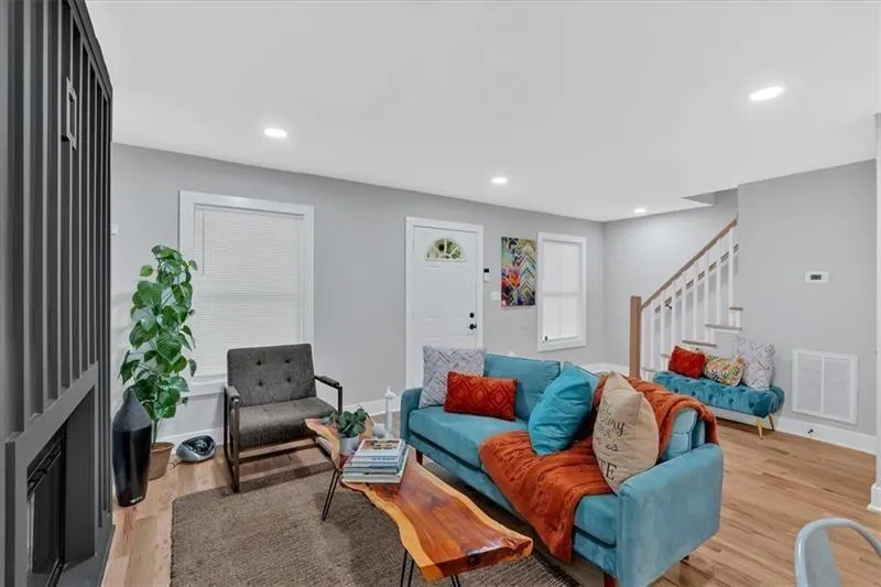Living room with stairs, light wood-style flooring, and recessed lighting