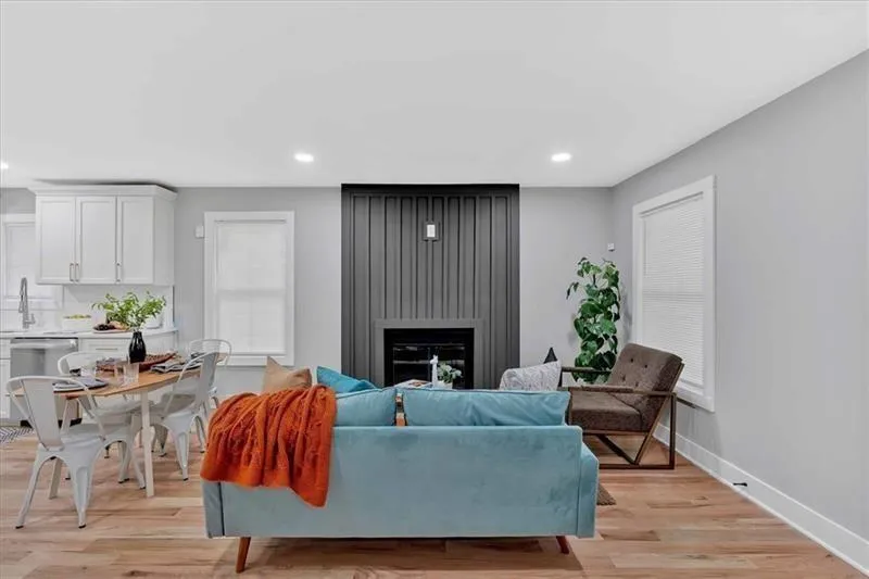 Living area with light wood finished floors, a large fireplace, and recessed lighting