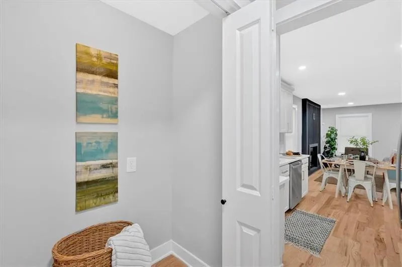 Corridor with light wood-style flooring and baseboards