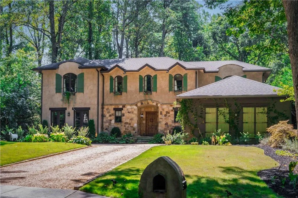 Stucco exterior with stone accents and a gravel driveway