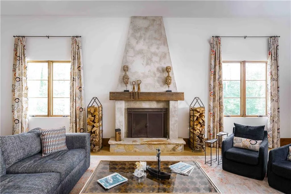 Central fireplace featuring a stone hearth and wood mantel