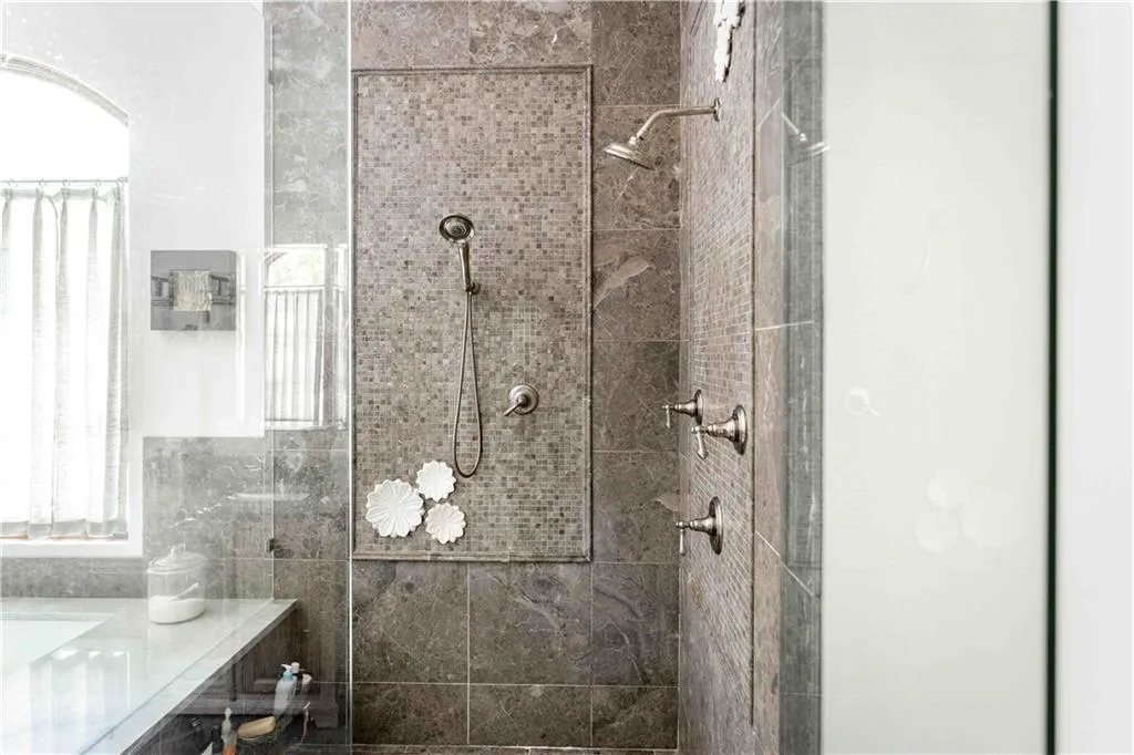 Shower featuring full-height mosaic tile, a handheld showerhead, and a wall-mounted showerhead
