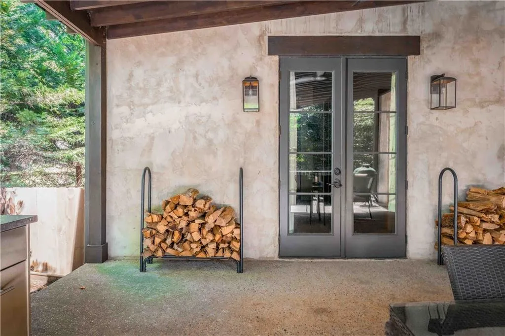 Covered patio featuring textured stucco walls and dark-framed French doors