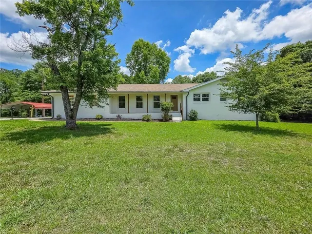 White painted exterior with a covered front porch and brown door