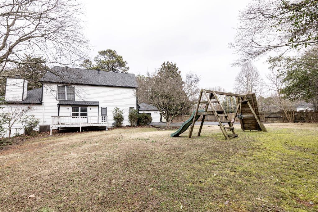 View of yard with a deck and a playground