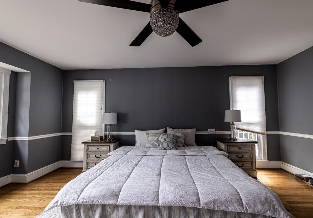 Bedroom featuring multiple windows, light hardwood / wood-style flooring, and ceiling fan
