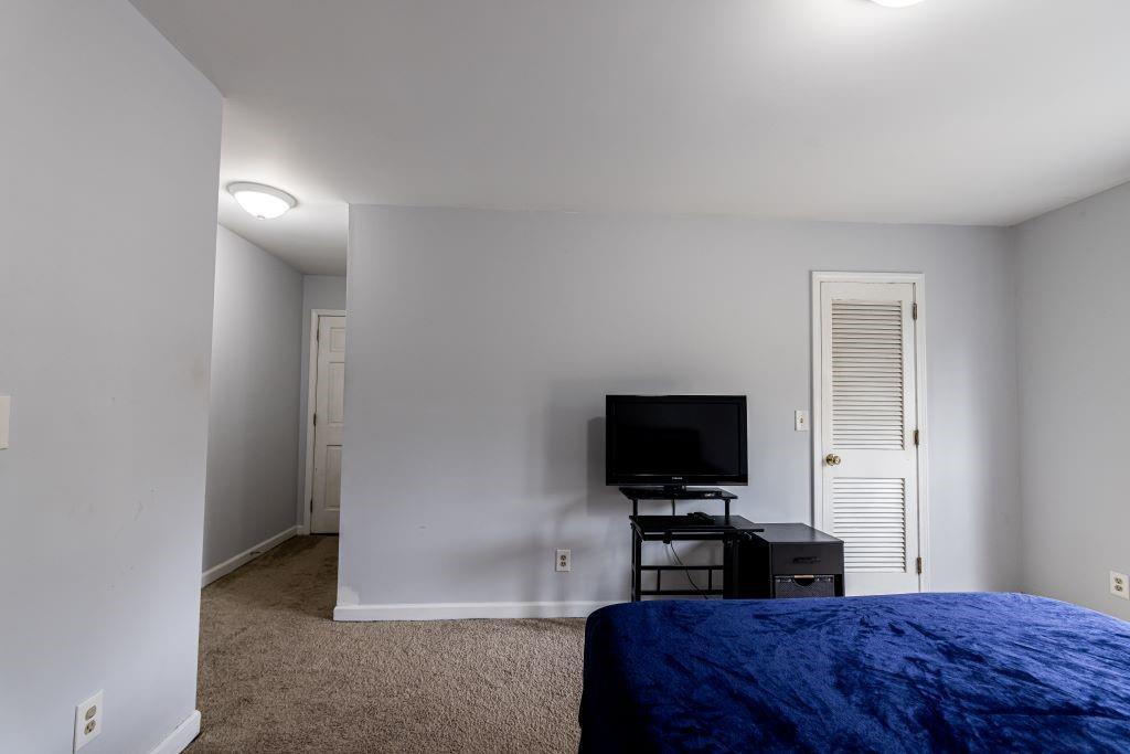 Carpeted bedroom with a closet
