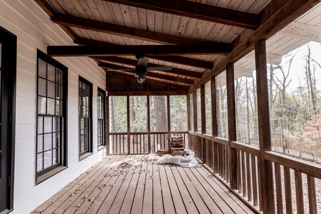 Unfurnished sunroom featuring lofted ceiling with beams, wooden ceiling, and ceiling fan