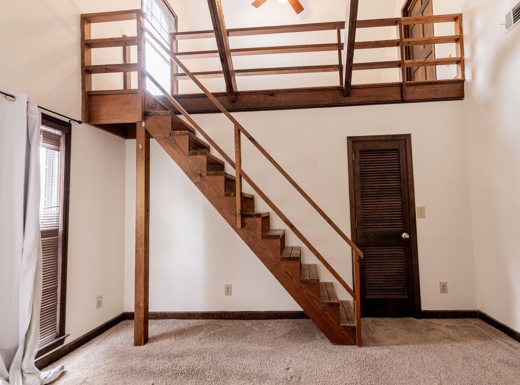 Staircase featuring light carpet, a high ceiling, and ceiling fan