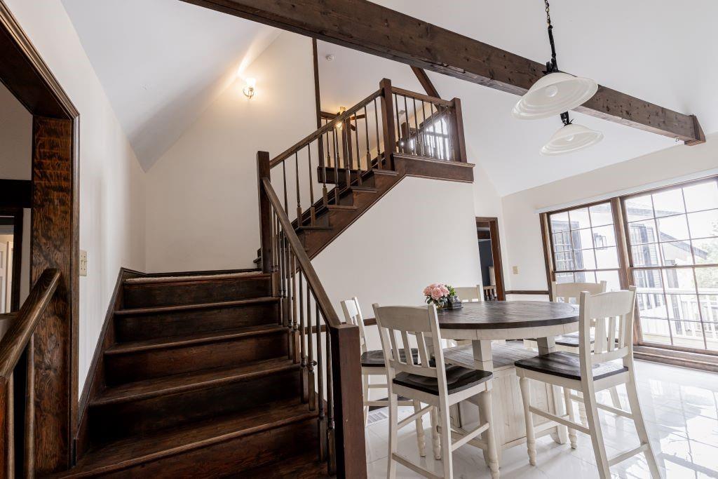 Dining area featuring light tile flooring, high vaulted ceiling, and beamed ceiling
