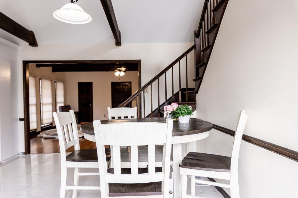 Dining area with wood-type flooring and beam ceiling