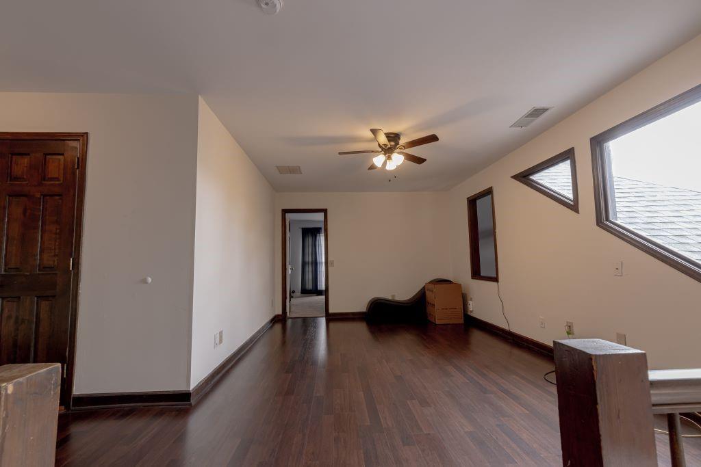 Empty room with dark hardwood / wood-style floors and ceiling fan