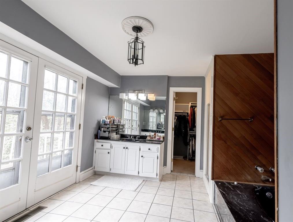 Bathroom featuring french doors, tile floors, and vanity
