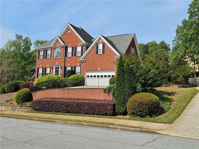 Traditional brick exterior featuring a multi-gabled roofline and attached garage