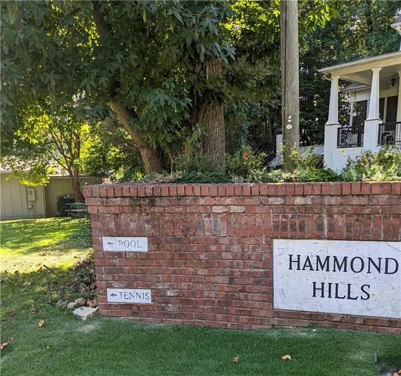 Community / neighborhood sign featuring a lawn