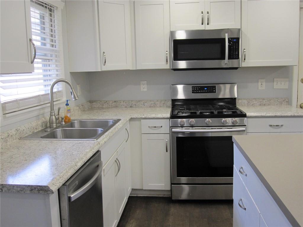 Kitchen with Breakfast Bar/Island, white cabinets & stainless steel appliances