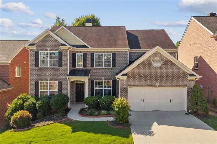 Brick exterior with black shutters and a covered entryway