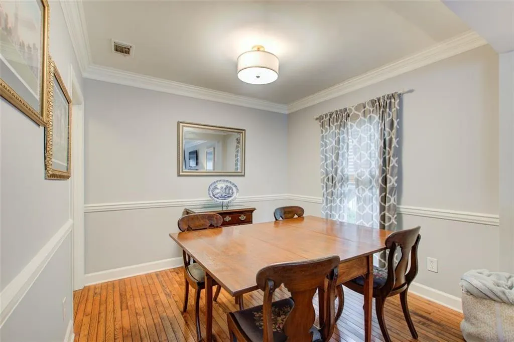Dining space featuring ornamental molding and wood-type flooring