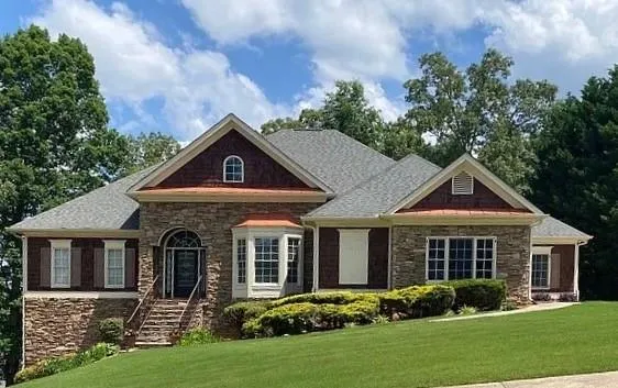 Stone and shingle exterior with a prominent arched entry